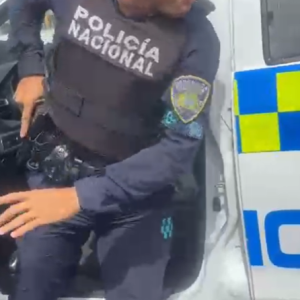Agente de Policía manipula arma frente a periodistas en Santo Domingo Este