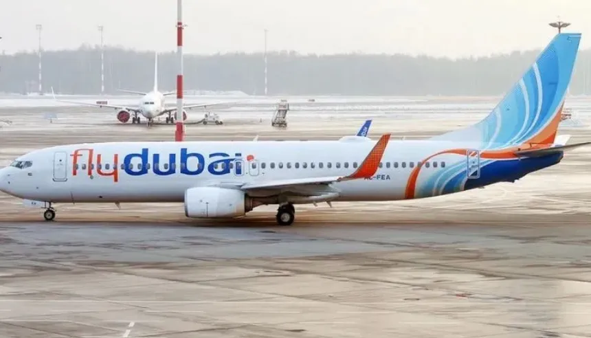 Avión comercial de la aerolínea Flydubai volando en cielo despejado.
