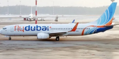 Avión comercial de la aerolínea Flydubai volando en cielo despejado.