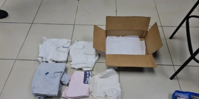 Agentes de la DNCD e inspectores procesando evidencias en una empresa de envíos internacionales en el Distrito Nacional.
